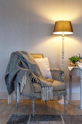 a blanket on a chair in a room with a lamp at Botanica in Dánszentmiklós