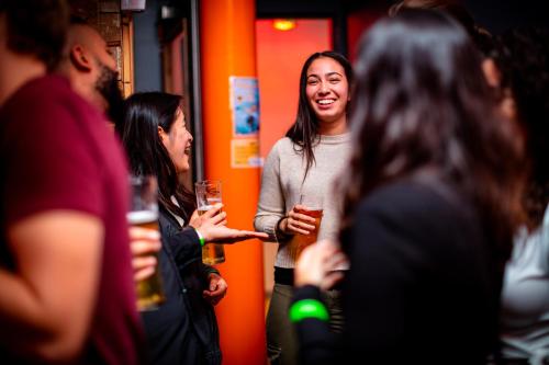 two women standing in a bar holding drinks at Kick Ass Greyfriars (18+) in Edinburgh