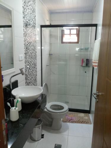 uma casa de banho com um chuveiro, um WC e um lavatório. em Casa 1/4 Chapada Diamantina/ibicoara em Ibicoara