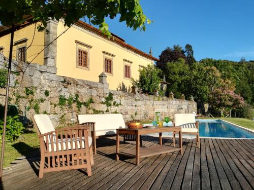 um pátio com uma mesa e cadeiras ao lado de uma piscina em Paço de S.Cipriano em Guimarães