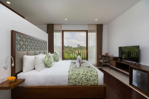 una camera con un grande letto e una televisione di Athaya Ubud ad Ubud