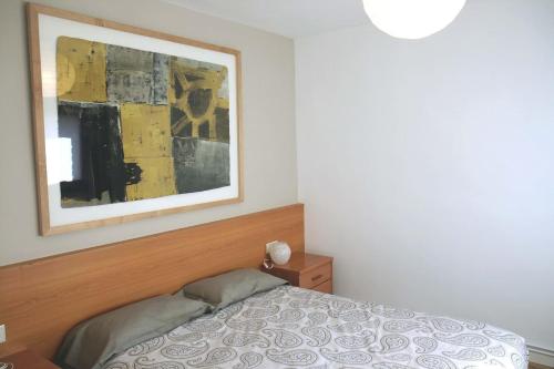 1 dormitorio con 1 cama y una pintura en la pared en apartament Eliette 2 en Bagá