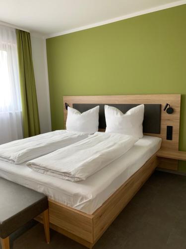 Weingut Bugner Meizelhof في Klein-Winternheim: غرفة نوم بسرير كبير عليها شراشف ووسائد بيضاء