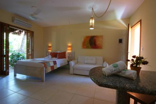 1 dormitorio con 1 cama y sala de estar en Pousada Vento Sul, en Ilhabela