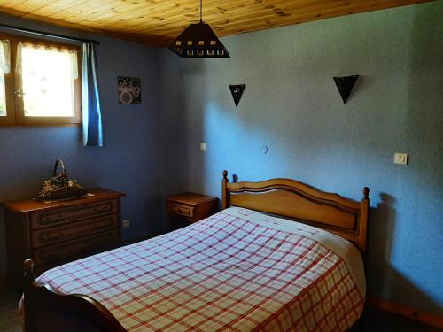 ein Schlafzimmer mit einem Bett, einer Kommode und einem Fenster in der Unterkunft Gîte Les Grands Champs in Bellentre