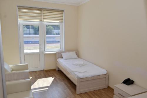 a small room with a bed and a window at Pakhtakor Athletics hotel in Tashkent