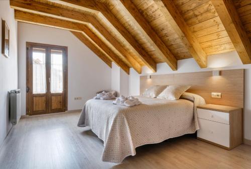 a bedroom with a bed in a room with wooden ceilings at Casa Marosa in Ansó