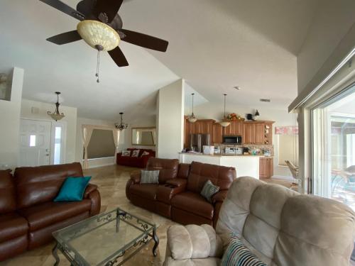 a living room with leather furniture and a ceiling fan at Modern Pool Home in Spring Hill