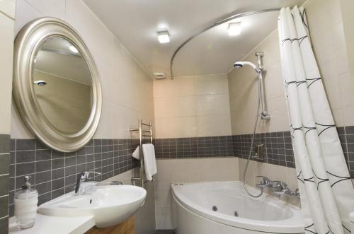a bathroom with a sink and a tub and a mirror at To Kastri in Kalopanayiotis