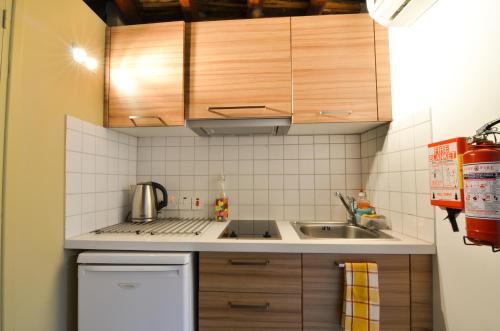 a small kitchen with wooden cabinets and a sink at To Kastri in Kalopanayiotis