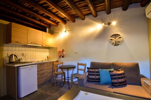 a kitchen and living room with a couch and a table at To Kastri in Kalopanayiotis