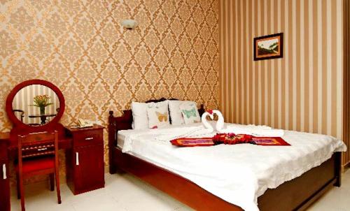 Un dormitorio con una cama con un cisne. en Nathalie's Vung Tau Hotel, en Vung Tau