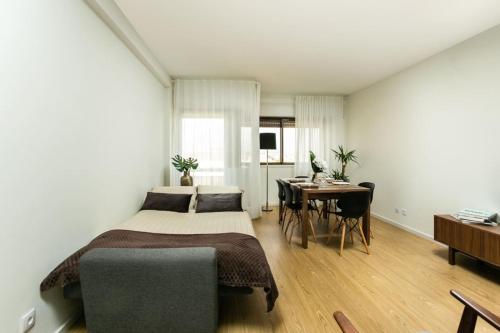 a bedroom with a bed and a table and a desk at APOSENTUS - Elegant Functionality Porto Downtown in Porto