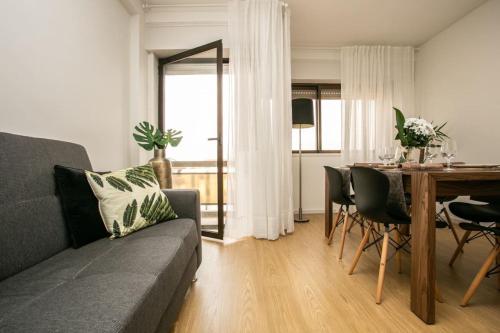 a living room with a couch and a table at APOSENTUS - Elegant Functionality Porto Downtown in Porto