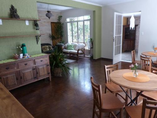 sala de estar con 2 mesas, sillas y sofá en Zen Hostel Brasil, en São Paulo