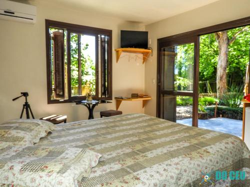 um quarto com uma cama e vista para um quintal em Espaço Holístico Chalés em Nova Petrópolis