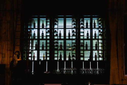 a woman sitting in front of a window with wine glasses at Hotel Lago Grey in Torres del Paine