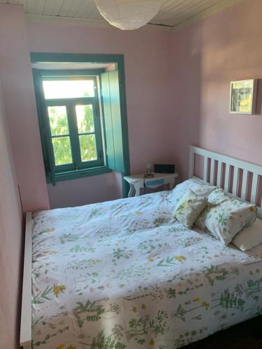 a bedroom with a bed and a window at São Miguel House , Casa do Carvalhal in Santarém