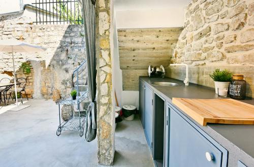 kuchnia z blatem i kamienną ścianą w obiekcie PIKARIN ROOMS w mieście Vrsar