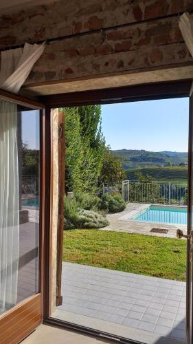 a sliding glass door with a view of a pool at La Vigna del Parroco-2- in Serralunga d'Alba