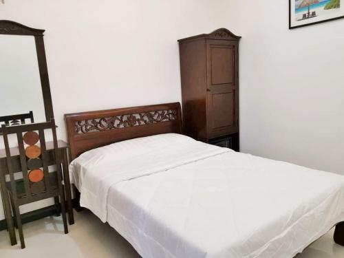 a bedroom with a bed and a dresser in it at MJ Pension House in Talisay