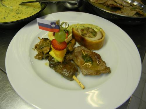 a white plate of food with meat and vegetables at Hotel Krona Domžale in Domžale