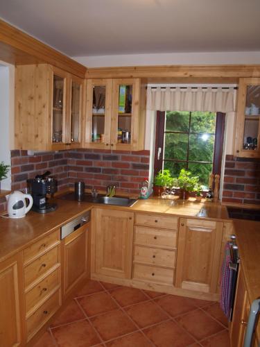 a kitchen with wooden cabinets and a window at Penzion Vital in Liberec