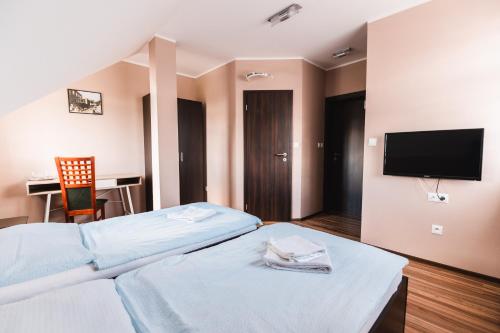 a hotel room with two beds and a flat screen tv at Motel ARD in Sarovce