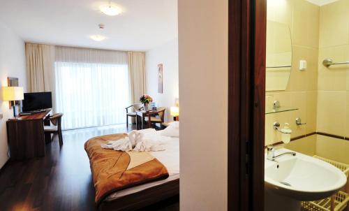 una camera d'albergo con letto e lavandino di Bursztyn Spa a Kołobrzeg
