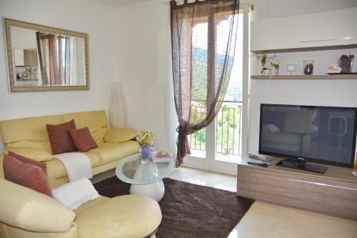 a living room with a yellow couch and a television at Casa la Pianca in Menaggio