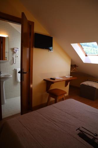 um quarto com uma cama e uma casa de banho com uma janela em Alojamento Santa Clara em Manteigas