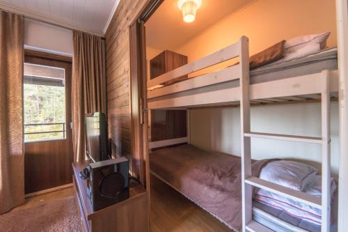 - une chambre avec des lits superposés, une télévision et un miroir dans l'établissement Villa Ylläs 301, à Ylläsjärvi