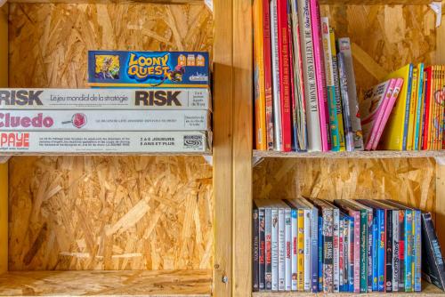 a wooden book shelf filled with books at L Her Beau d Hier in LʼÉpine
