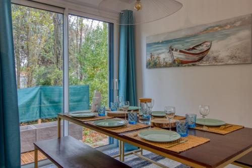 a dining room with a table and a large window at L Her Beau d Hier in LʼÉpine