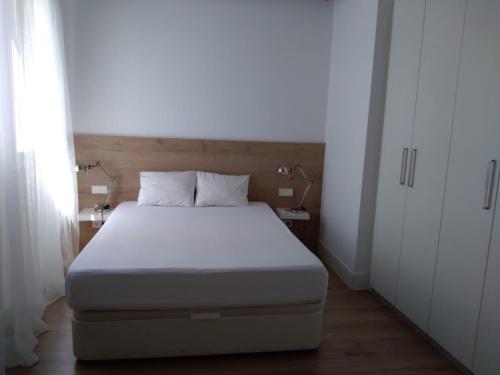 a bedroom with a bed with a white bedspread and white cabinets at Great apartment with excellent location (Calle Fuencarral/Gran Via/Chueca) in Madrid