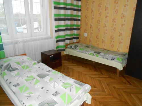a room with two beds and a window at Hostel Noclegi Chorzow in Chorzów