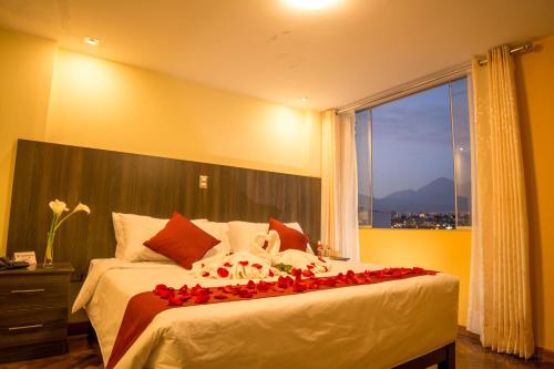 a bedroom with a bed with red roses on it at Hotel Incamin Mirador in Arequipa