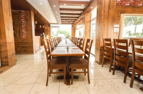 a long dining room with a long table and chairs at Hotel Buddha House Himalayan Brothers in Dharamshala