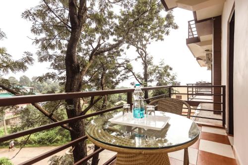 a table on a balcony with a tree at Hotel Buddha House Himalayan Brothers in Dharamshala