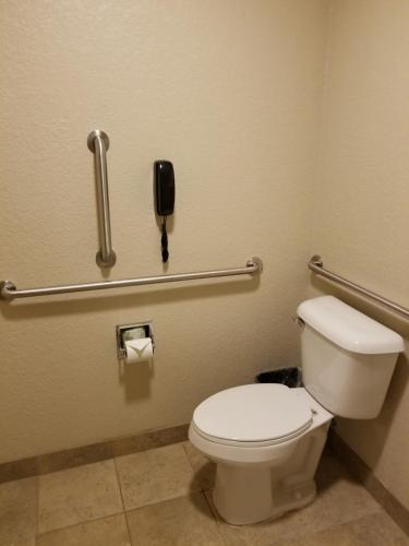 a bathroom with a toilet and a phone on the wall at Cobblestone Inn & Suites - Clarion in Clarion