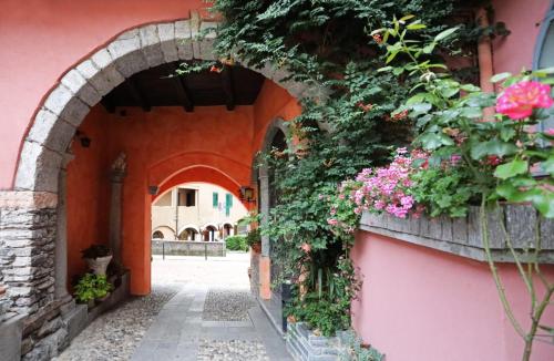 an archway with flowers on a pink building at Ca' De' Mumi in Luino