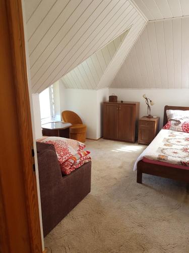 a attic room with a bed and a couch at Chata Baby Jagi in Krzywe