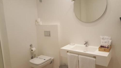 a bathroom with a sink and a toilet and a mirror at Apartamento Palacio Azcárate Marisa Sanchez in Ezcaray