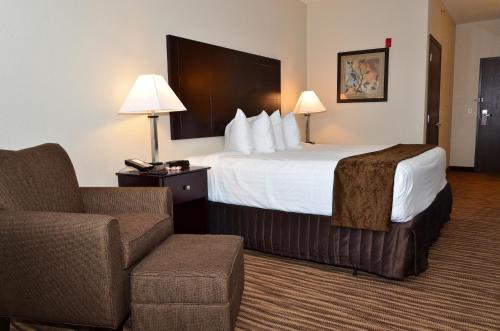 a hotel room with a bed and a chair at Cobblestone Inn & Suites - Clarion in Clarion