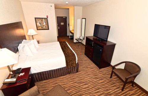 a hotel room with a bed and a flat screen tv at Cobblestone Inn & Suites - Clarion in Clarion