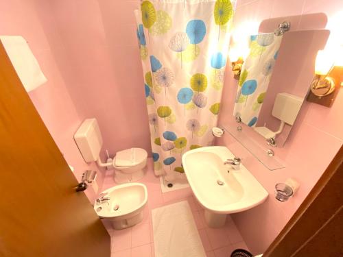 a bathroom with a sink and a toilet and a mirror at Hotel Pamela in San Pietro in Casale