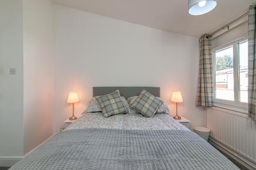 a bedroom with a large bed with two lamps at Hillcrest Lodge in Stevenage