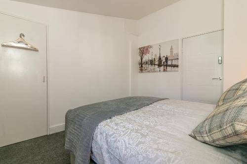 a bedroom with a bed and a painting on the wall at Hillcrest Lodge in Stevenage