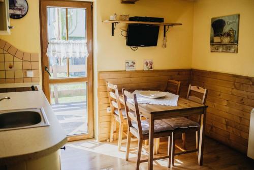 a kitchen with a table and chairs and a television at U Haliny - Tyra Natura in Třinec