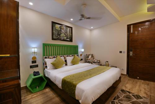 a bedroom with a large bed with a green headboard at Hotel Blue Pearl - Free Airport Pick up in New Delhi